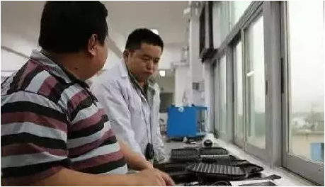 ▲朱达·黄（音）所在公司的技术人员讨论不粘锅涂层的生产（《华尔街日报》）